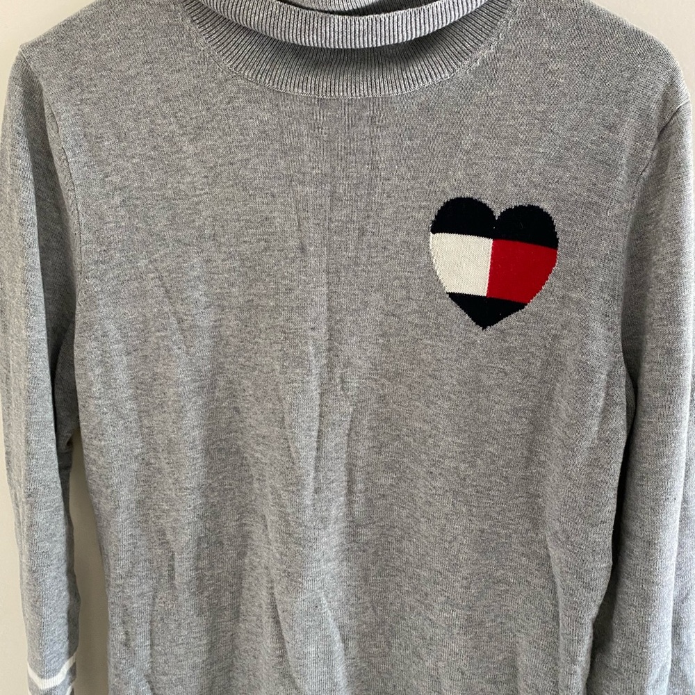 Pullover sweater in grey. The sleeves have white lines. In excellent condition.